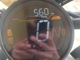 a person taking a picture of a motorcycle ' s speedometer