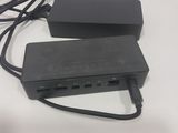 une multiprise noire branchée sur un chargeur posé sur une table blanche