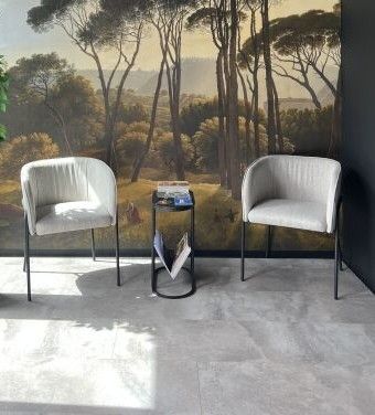 deux chaises et une table devant un mur sur lequel est accroché un tableau