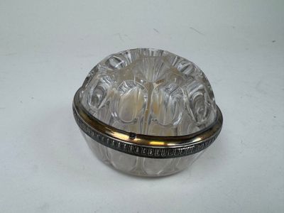 a glass bowl with a silver lid on a white surface