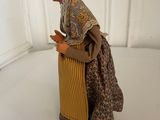 a figurine of a woman in a dress and bonnet