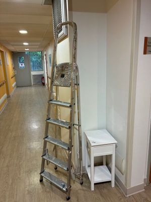 une échelle appuyée contre un mur dans un couloir