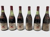 six bouteilles de vin sont alignées sur une surface blanche