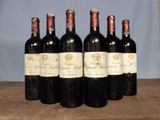 six bottles of wine are lined up on a wooden table