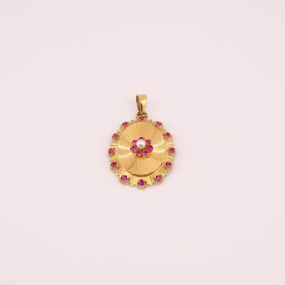 un pendentif en or orné de pierres roses sur fond blanc