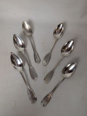 six silver spoons are arranged in a circle on a white surface