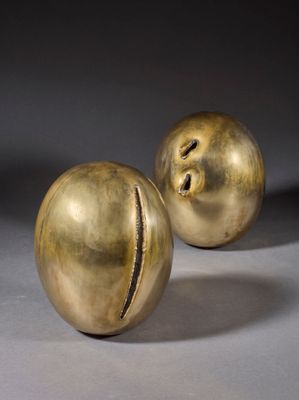 paire de figurines en laiton représentant un homme et une femme, posées sur un socle gris
