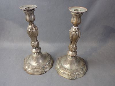 two silver candlesticks that are sitting on a table