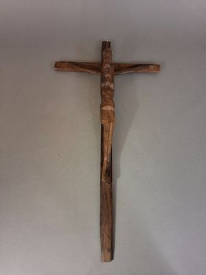 une croix en bois accrochée au mur d'une pièce