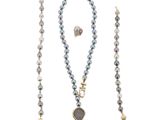un gros plan d'un collier et d'une paire de boucles d'oreilles sur fond blanc