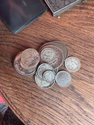 une pile de pièces posée sur une table à côté d'un portefeuille