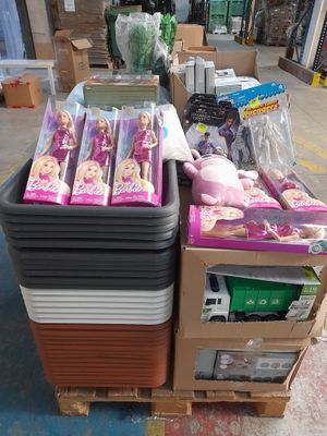 a pile of barbie dolls on a pallet in a warehouse