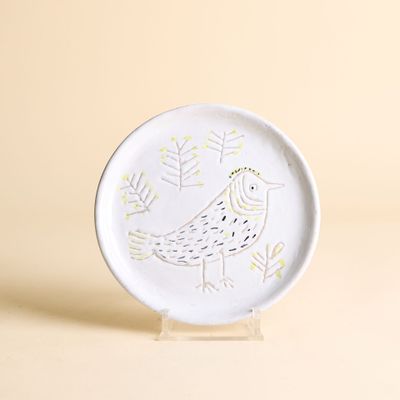 une assiette blanche sur laquelle est peint un oiseau