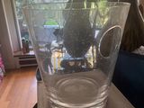 a glass vase sitting on top of a box in front of a window
