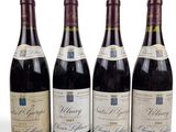 quatre bouteilles de vin sont alignées sur une surface blanche
