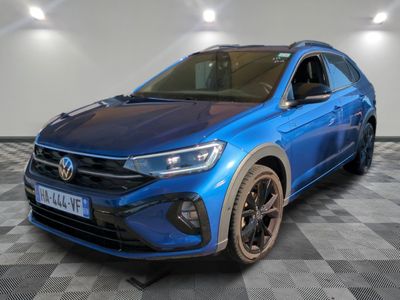 un SUV Volkswagen bleu garé sur un sol à damier dans un garage