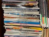 un grand nombre de DVD dans une boîte en carton posée sur le sol