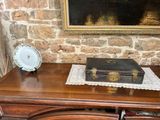 a wooden table with a suitcase on it and a clock on it