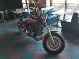 a motorcycle that is sitting in a room with a blue couch