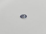 a close up of a blue sapphire stone on a white surface