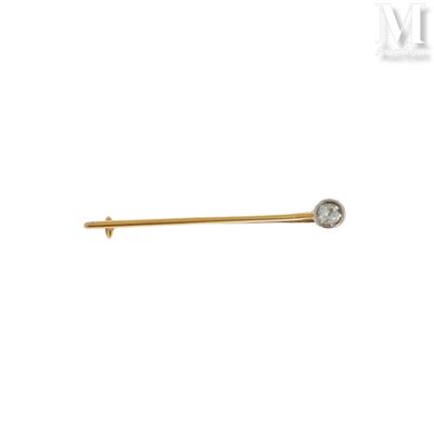 un gros plan d'une broche en or et diamants sur fond blanc