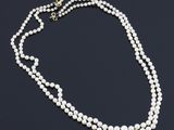a single strand pearl necklace with a gold clasp