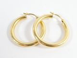 deux paires de boucles d'oreilles créoles en or sur fond blanc