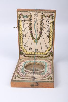 une vieille boîte en bois contenant une horloge, posée sur une surface blanche