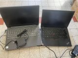 two open laptop computers sitting on a tiled floor next to each other