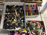many different types of buttons in boxes on a table