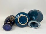 three blue vases and one blue vase sitting on top of a white table