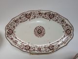 a brown and white plate on a table next to a cup
