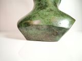 a green vase that is sitting on a white table