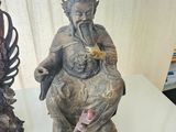 a statue of a man sitting on a chair next to a statue of a woman