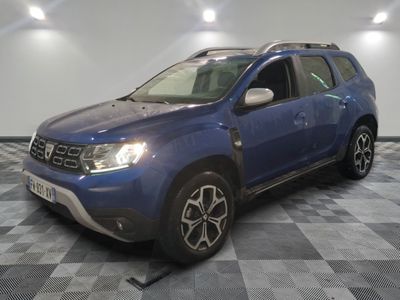 une photo d'une dacia bleue garée sur un sol en damier