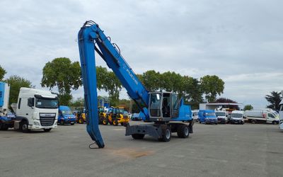 a blue crane on the back of a truck in a parking lot