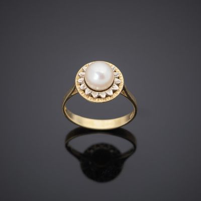 a gold ring with a pearl in the center