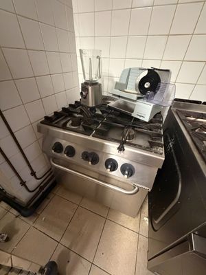 une cuisine équipée d'une cuisinière, d'un four et d'un mixeur