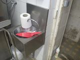 un distributeur de papier toilette contenant une spatule rouge