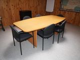 une table et des chaises dans une pièce où est accrochée une carte au mur