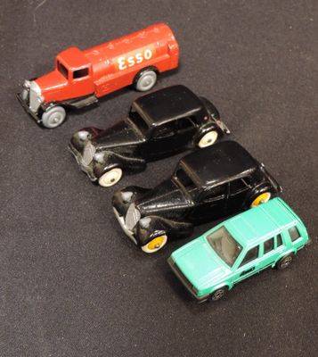 several toy cars are lined up on a black surface
