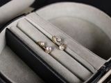 une paire de boucles d'oreilles dans un écrin posé sur une table