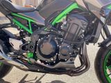 a green and black motorcycle parked on the side of the road