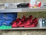 a metal table with a bunch of bags and bags on it