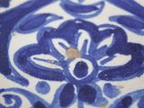 a close up of a blue and white plate with a bird on it