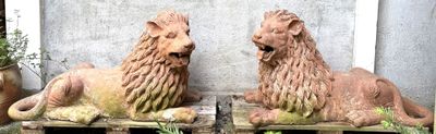 two statues of lions that are sitting on a pallet