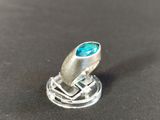 a close up of a silver ring with a blue stone in it