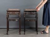 a woman that is standing next to two tables