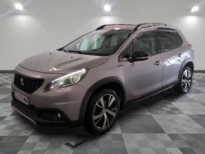 La voiture rose est garée sur le sol à damier du garage.