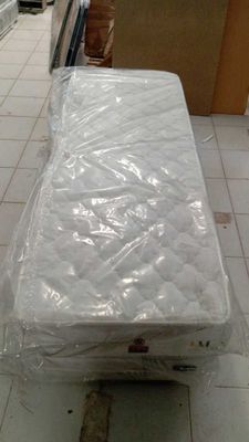 a mattress that is wrapped in plastic on the floor